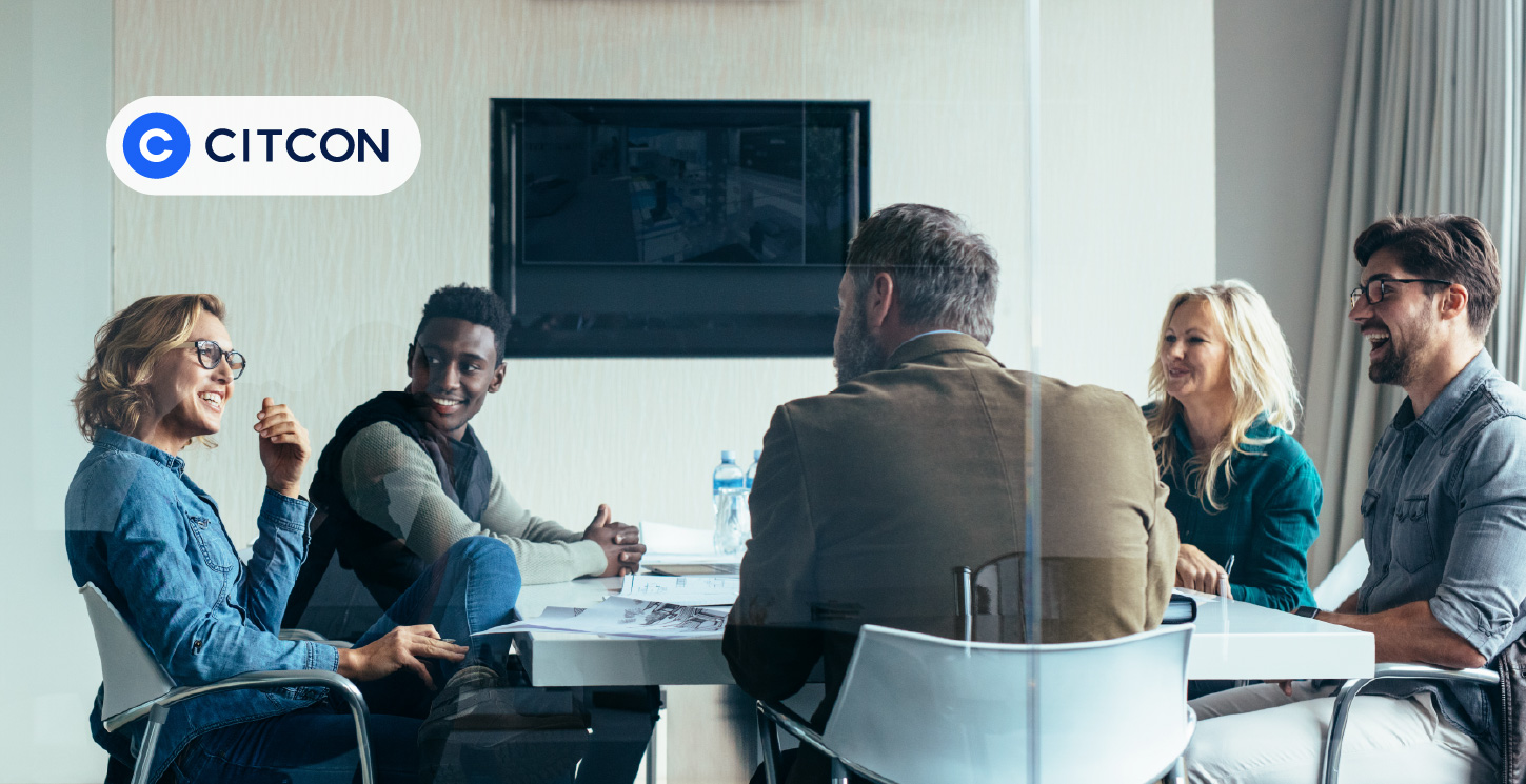 A group of executives sitting around a table in a conference room discussing the advantages of expanding a business internationally